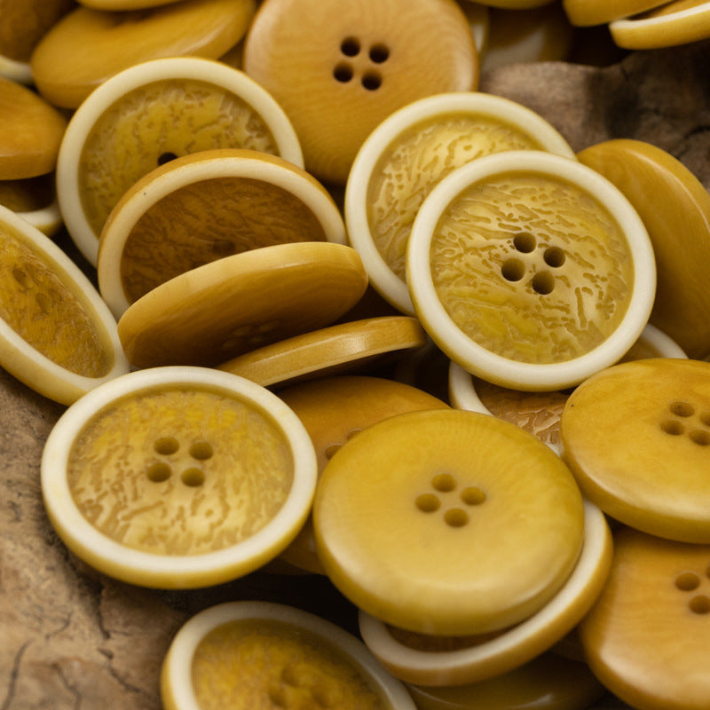 Multiple yellow fruit-pattern buttons with white rims; each button has four holes.