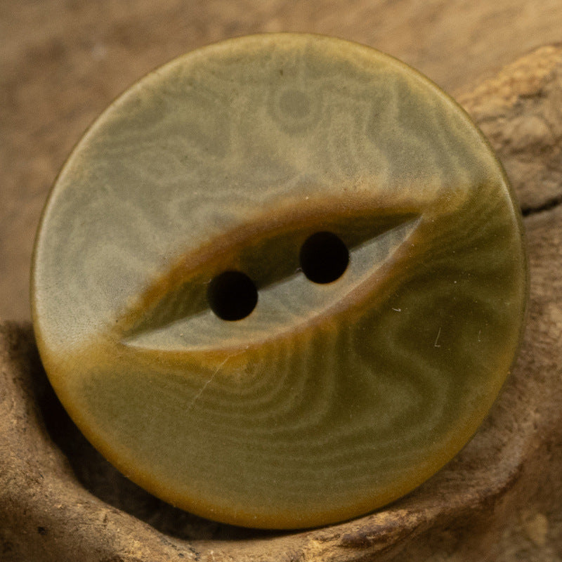 Olive green 2-hole nut button with vintage fish-eye swirl, smooth front detail