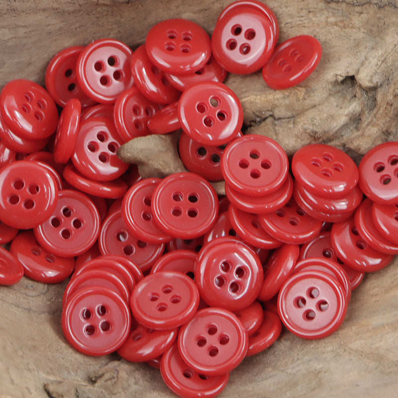 Red 4-hole urea buttons, multiple round fronts on wood surface