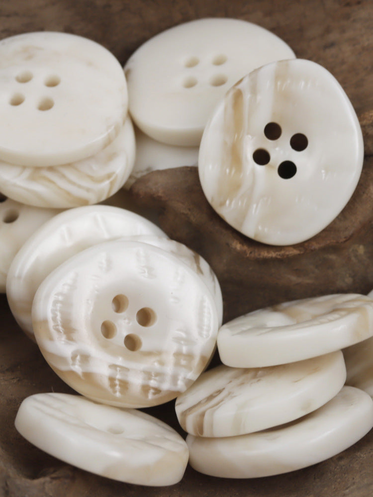 Beige/cream resin buttons with uneven surface and 4-hole design