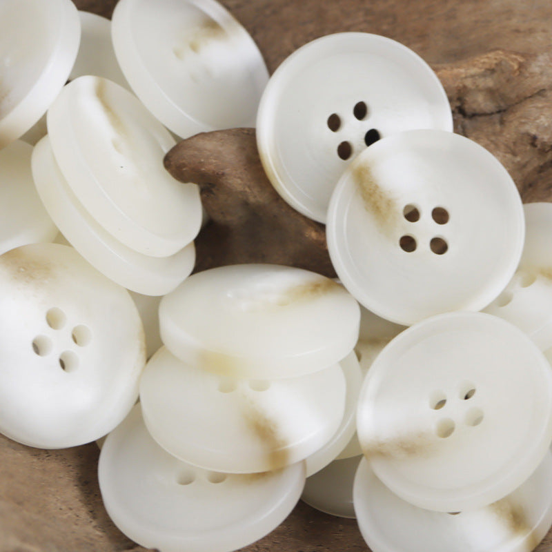 White resin flat buttons with four holes, round design