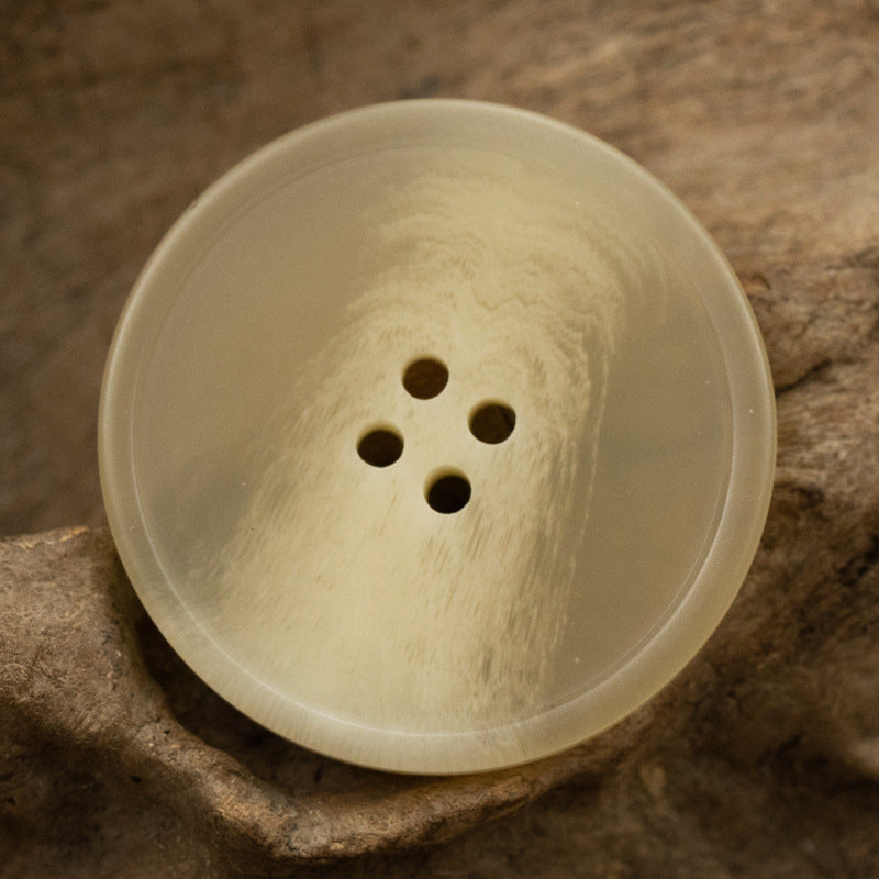 Light yellow round resin coat button with imitation horn texture and 4 holes