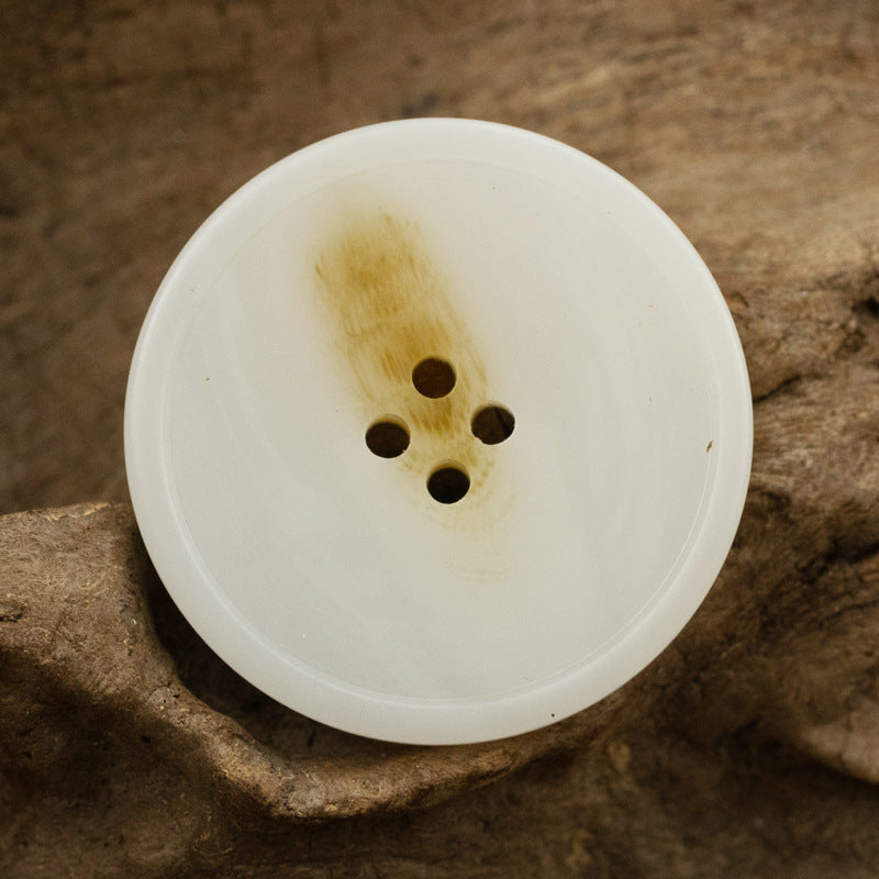 White round resin coat button with imitation horn texture and 4 holes
