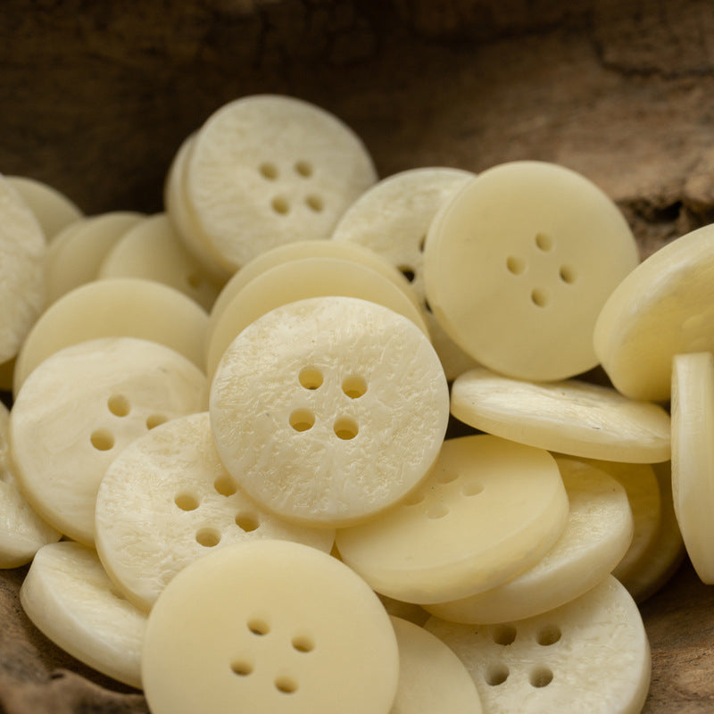 Light beige flat resin coat buttons with irregular texture, round 4-hole set