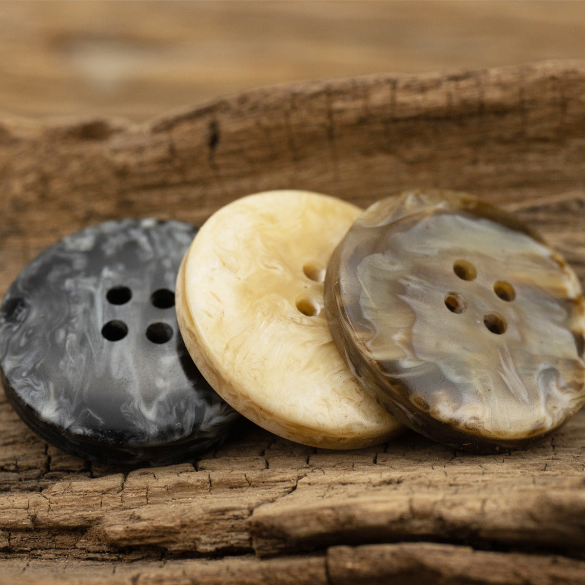 Set of marbled resin buttons on wood: charcoal, milky coffee, and translucent tan, 4 holes