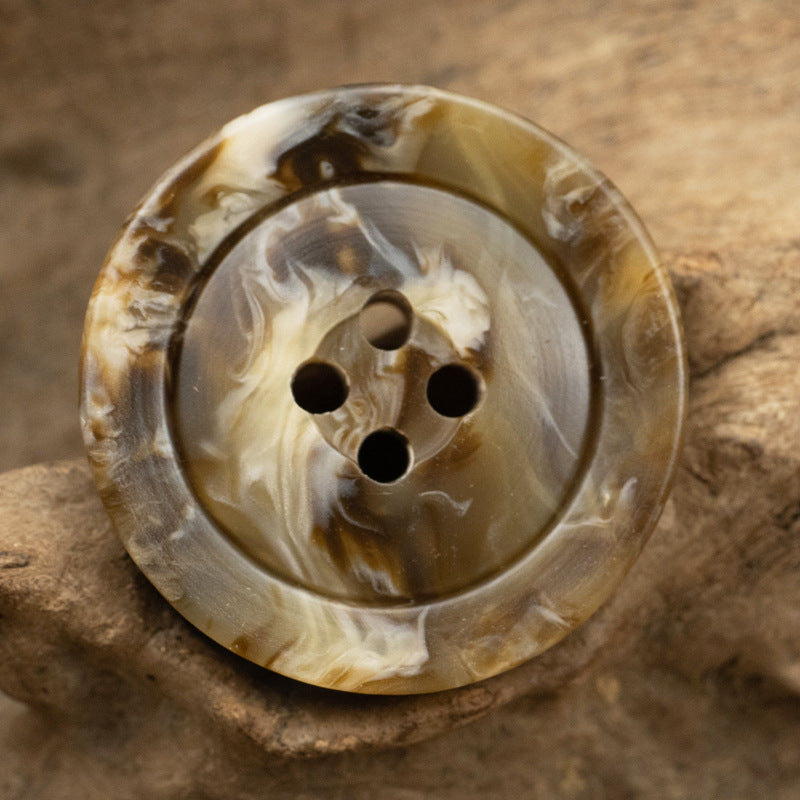 Translucent tan and milky coffee marbled resin button, wide rim, four holes, close-up