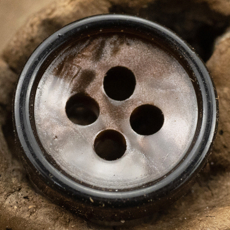 Close-up dark gray metallic 4-hole resin shirt button with dark edging