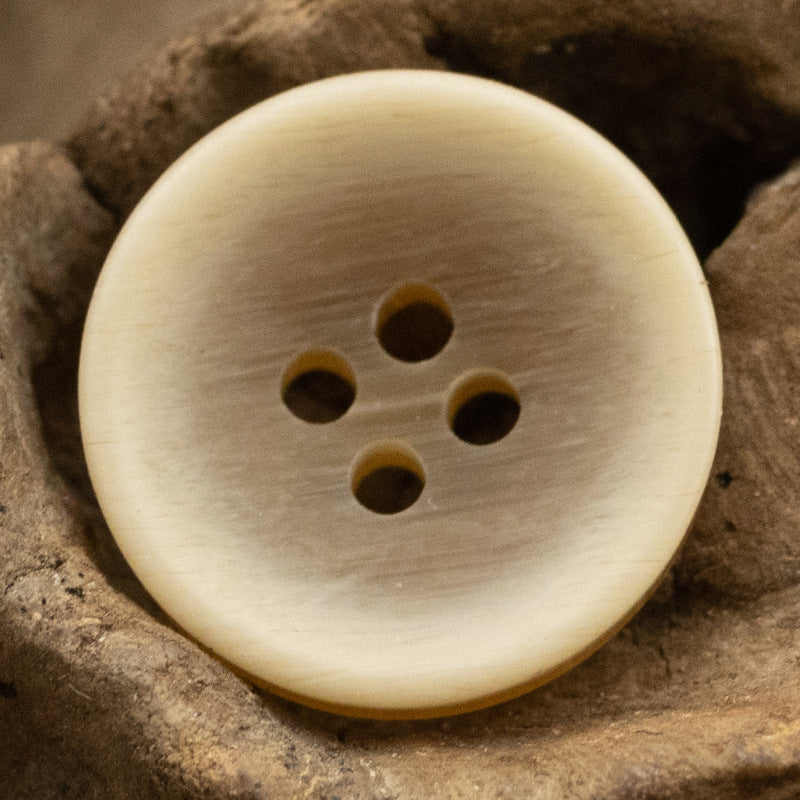 Light yellow matte bowl-shaped resin button, 4 holes, front view