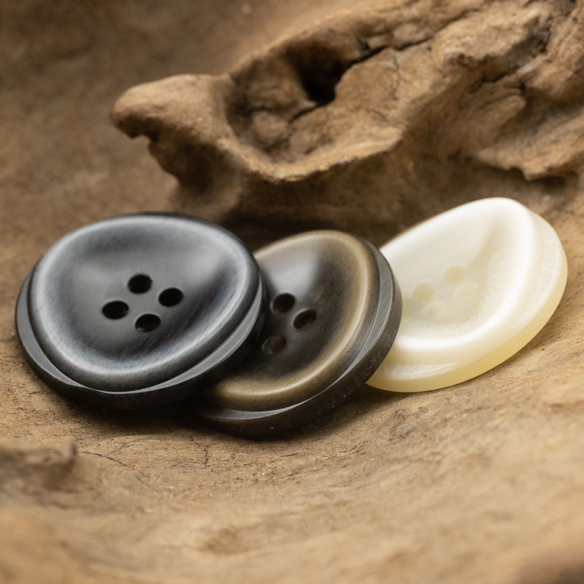 Resin buttons with 4 holes in dark bronze, gunmetal, and light ivory tones