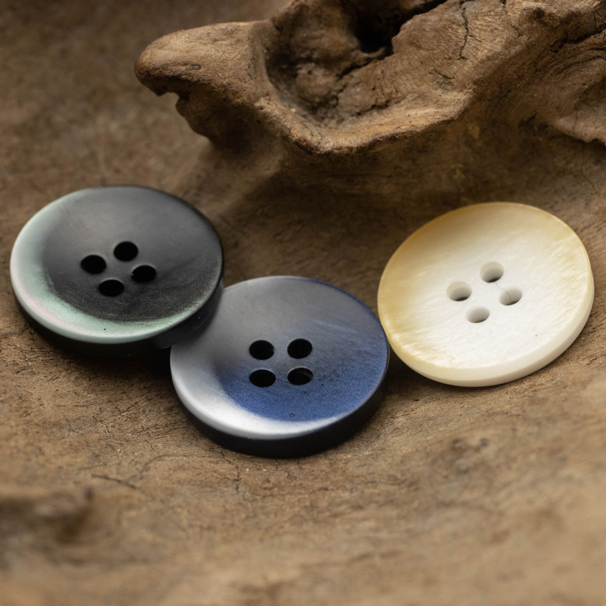 Blue-gray and cream resin buttons, flat with 4 holes each
