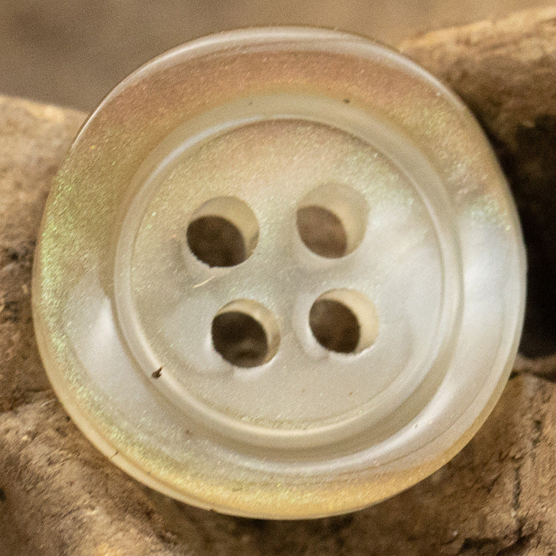Khaki translucent glazed pearl resin button close-up with four holes and wide rim
