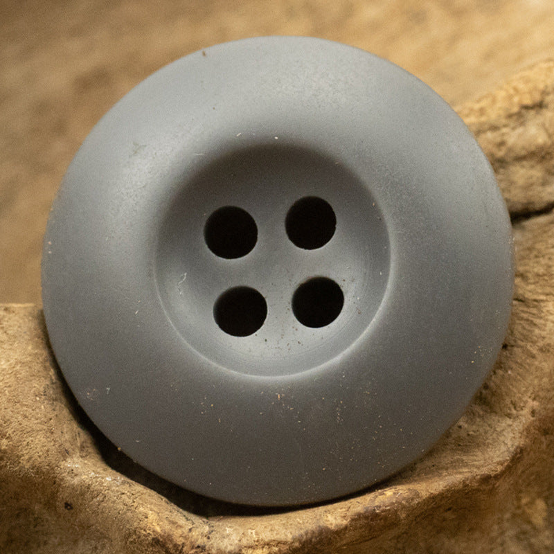 Single gray 4-hole resin button with four round holes.