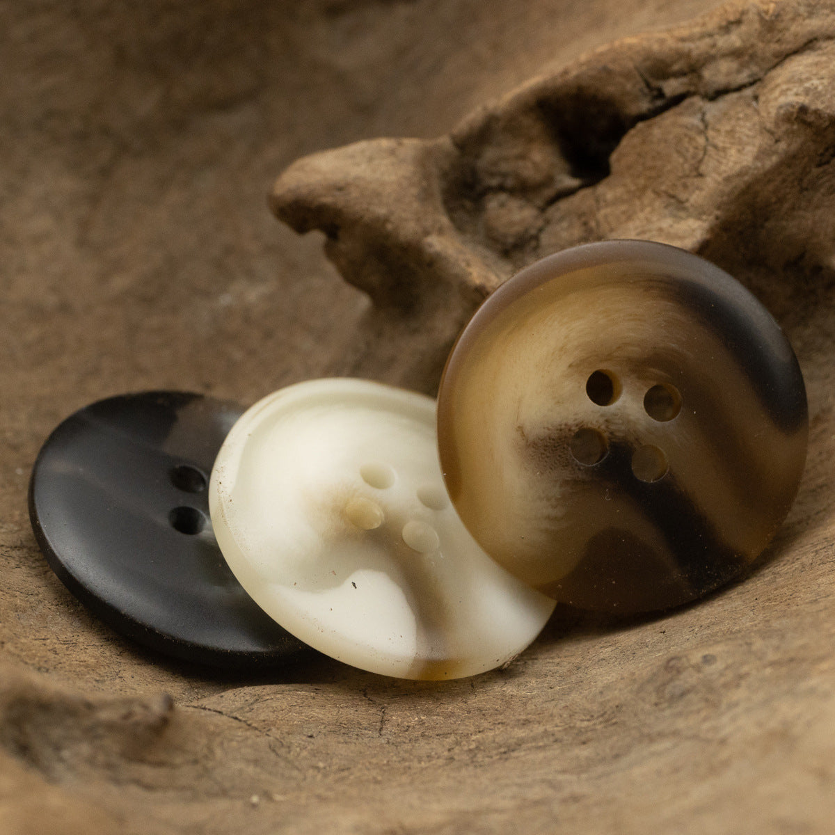 Uneven-surface resin button trio: dark brown, white, and black, each with 4 holes