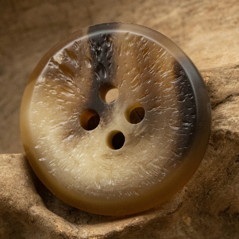 Uneven-surface resin button, light brown/amber tone, multiple holes