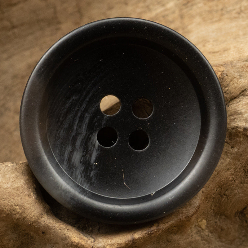 Black resin button, round with four holes