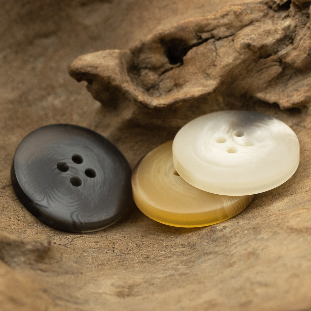 Matte 4-hole resin buttons: dark gray, yellow, beige in a group