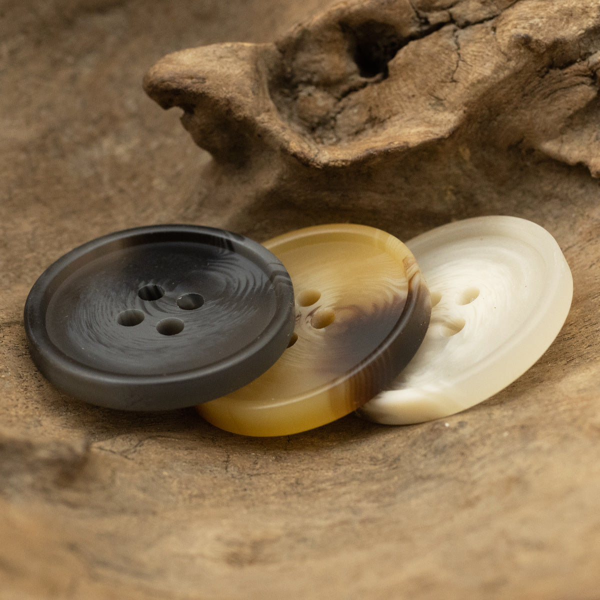 Matte 4-hole resin buttons on display: deep gray, yellow, beige