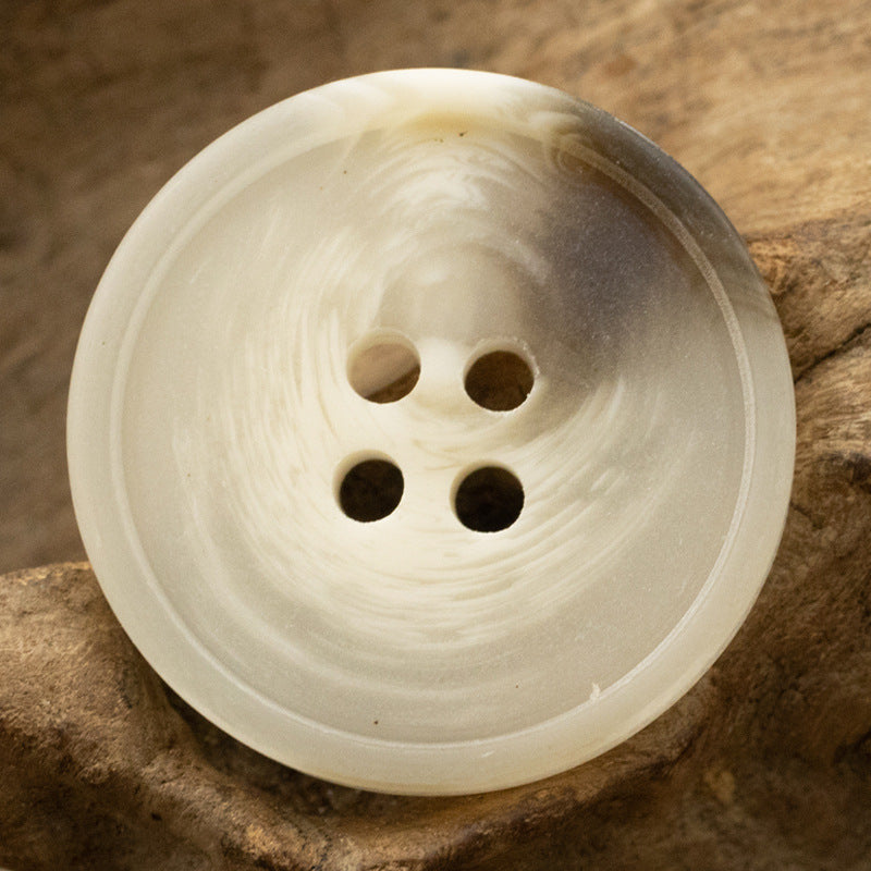 Round matte resin 4-hole button, beige/cream color closeup