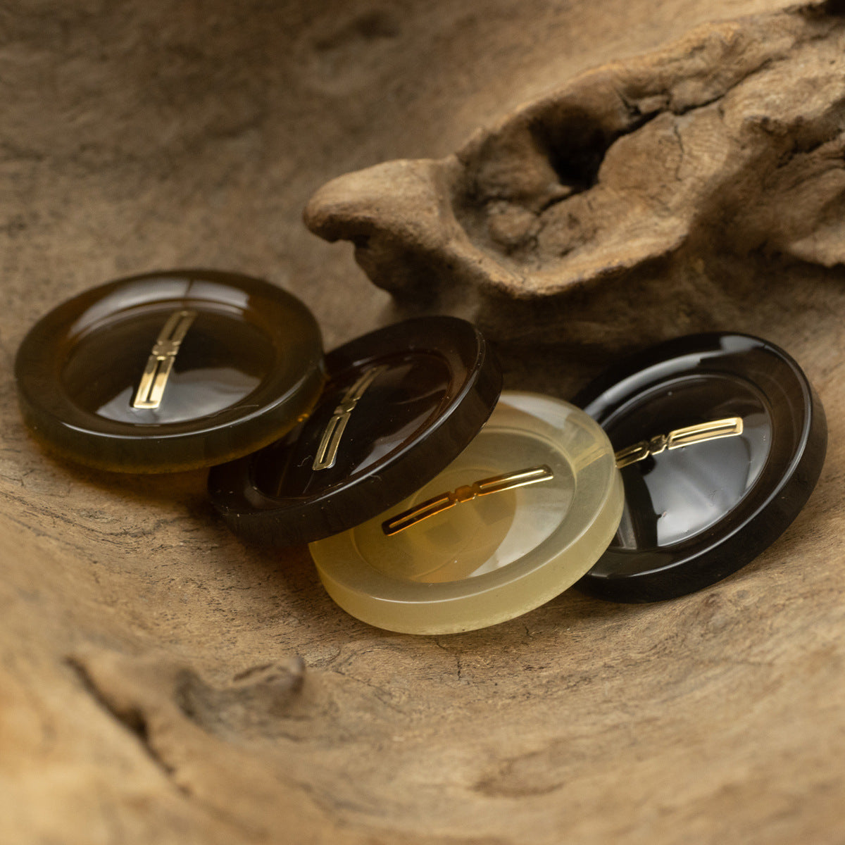 Translucent resin buttons in dark brown/black with gold-foil bar center