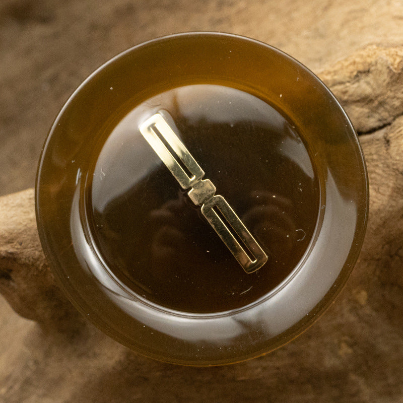 Translucent resin button, brown with gold-foil bar center detail