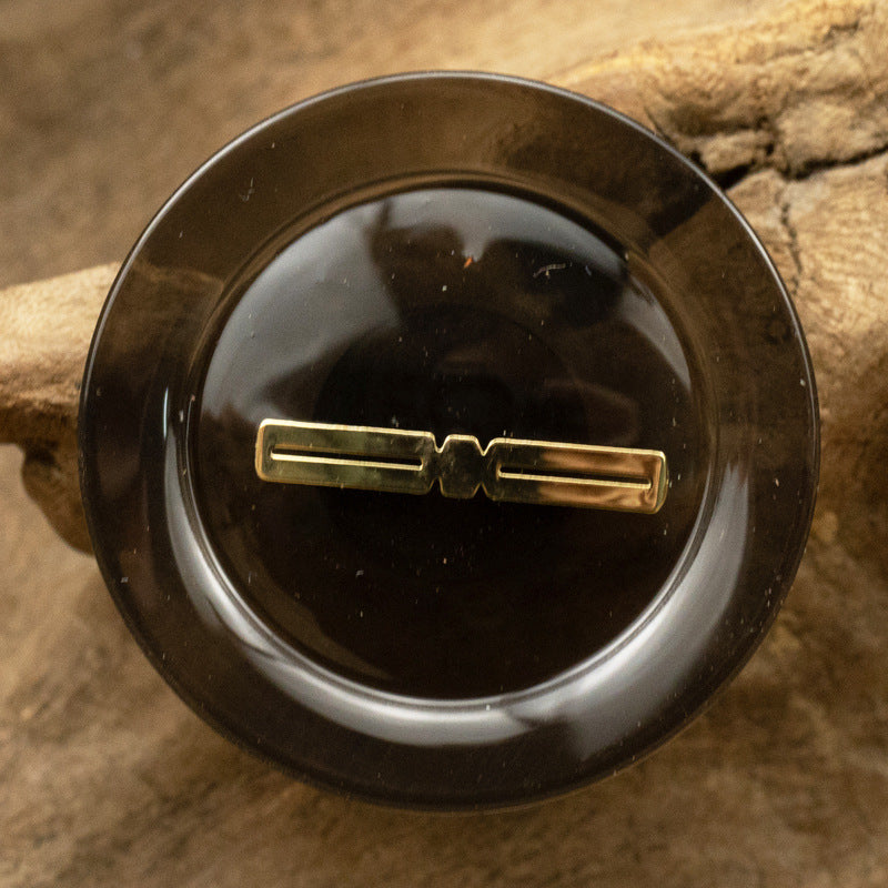 Translucent resin button, black, gold-foil bar center design