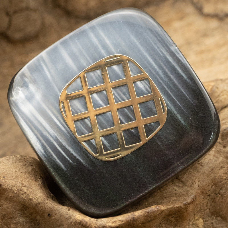 Square resin button in dark tone with champagne-gold grid pattern