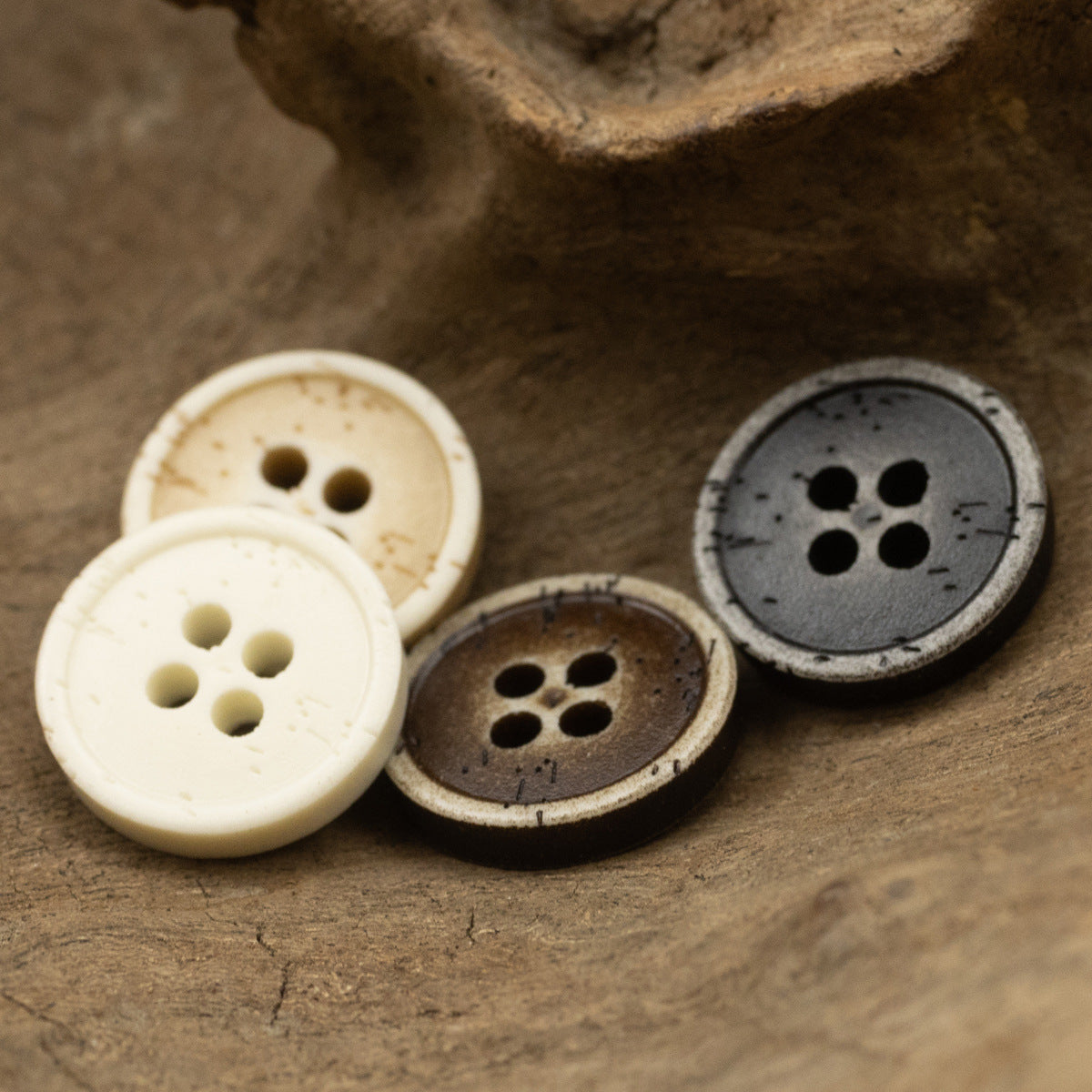 Distressed resin buttons with 4 holes: cream, tan, brown, dark gray (pack view).