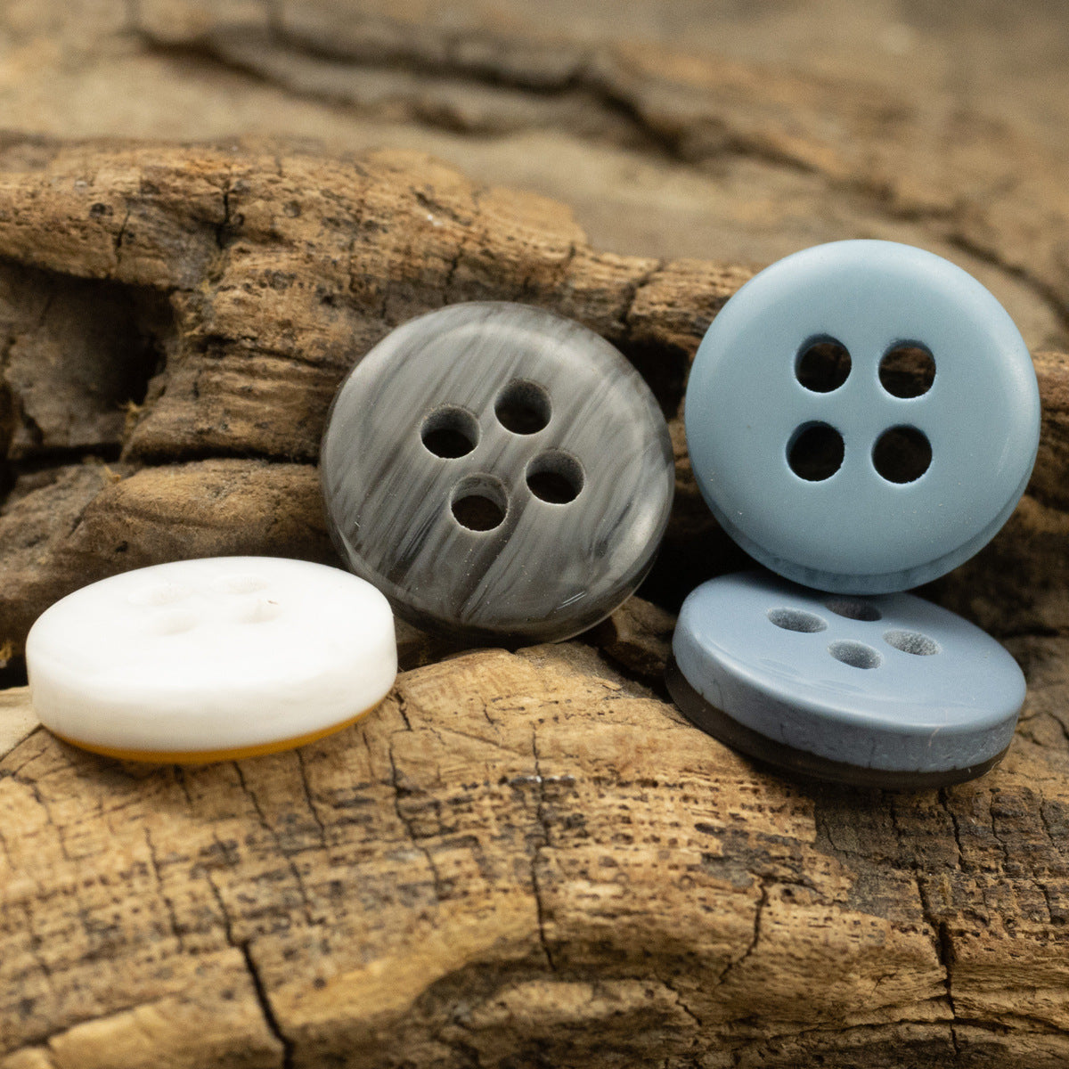 Resin buttons in yellow-white, lake blue, and dark gray tones, four-hole design