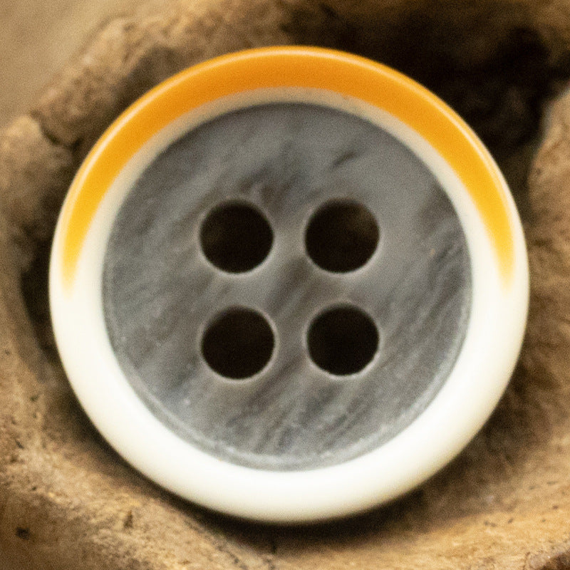 Gray resin button with yellow edge, four-hole design