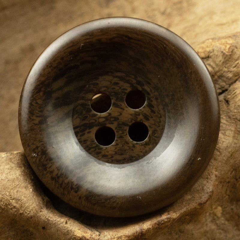 Wide-edged resin button in dark brown with lighter rim, four holes