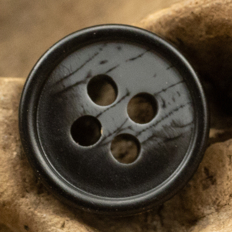 Black 11.5mm resin button with 4 holes and dark printed texture