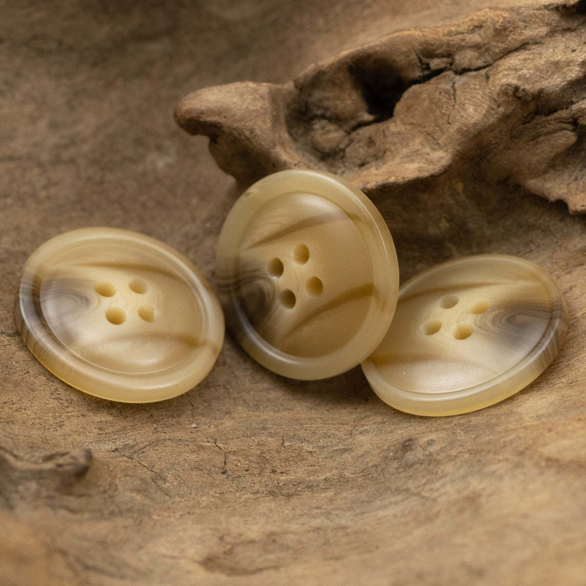 Four khaki resin coat buttons, round 4-hole style, smooth polished woodgrain