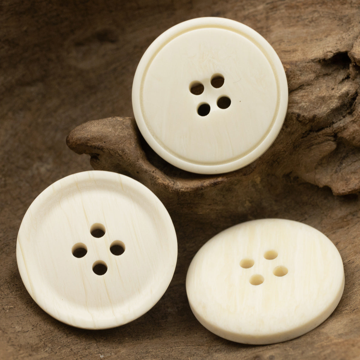 Set of white resin 4-hole buttons with ox-bone grain pattern