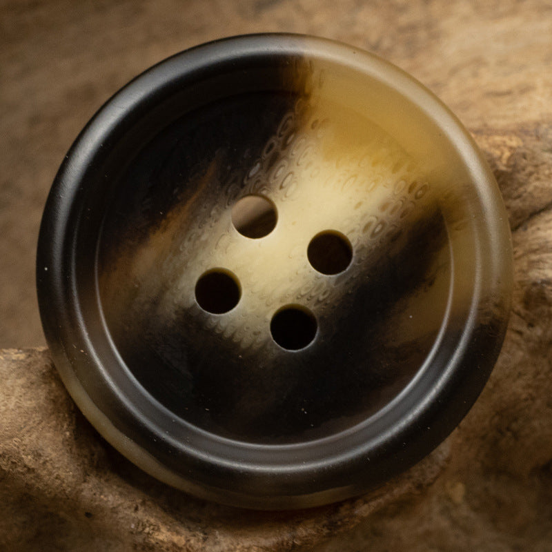 Two-tone brown resin button with four holes, dark rim and lighter center