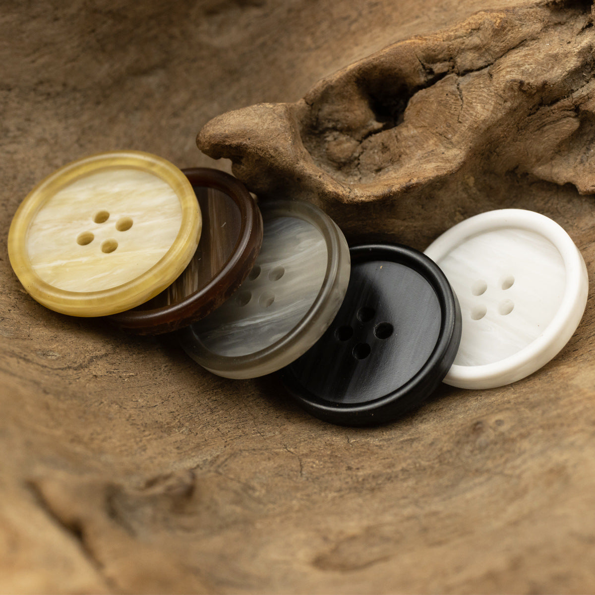 Assorted round resin buttons with 4 holes: yellow, brown wood-grain, gray, and white