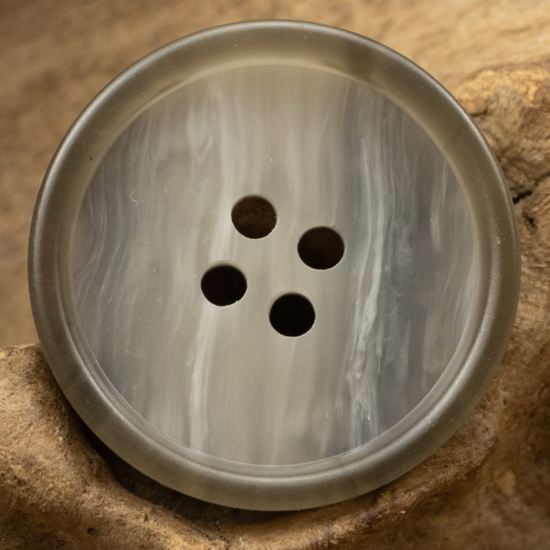 Gray round resin button with 4 holes and marbled wood-grain look