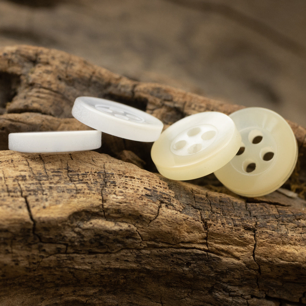 Light yellow and white resin buttons, 4-hole set, angled side view
