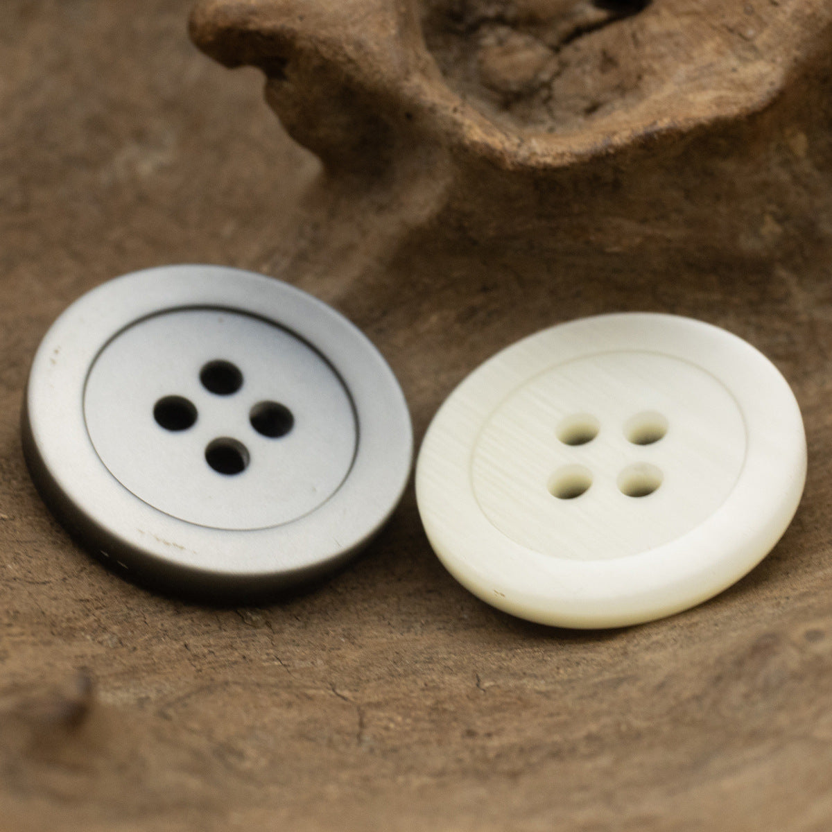 Matte round 4-hole resin buttons in gray and white, front view