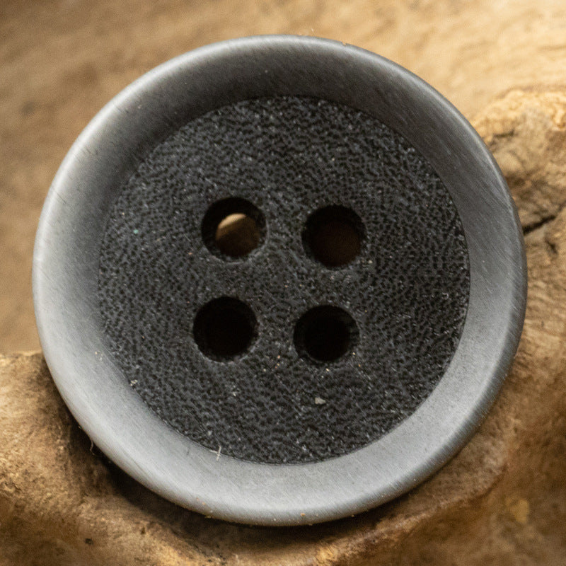 Black 4-hole resin sewing button, gradient frosted surface, close-up