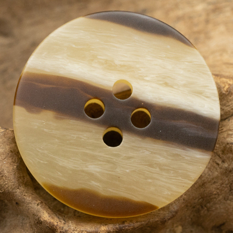 Round resin button, cream with dark horizontal stripe and 4 holes