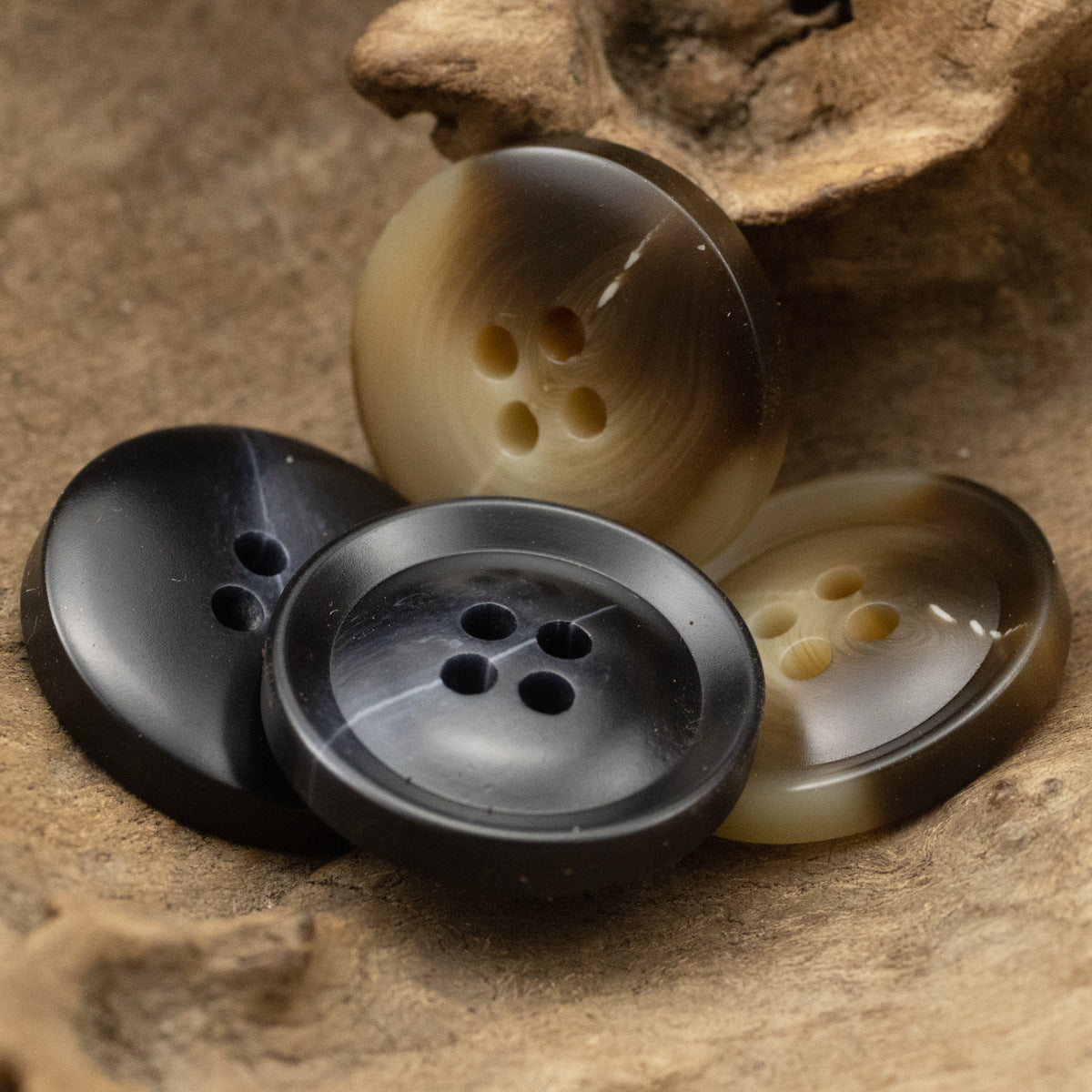 Resin suit buttons, 4-hole design, black and brown tones, assorted views.