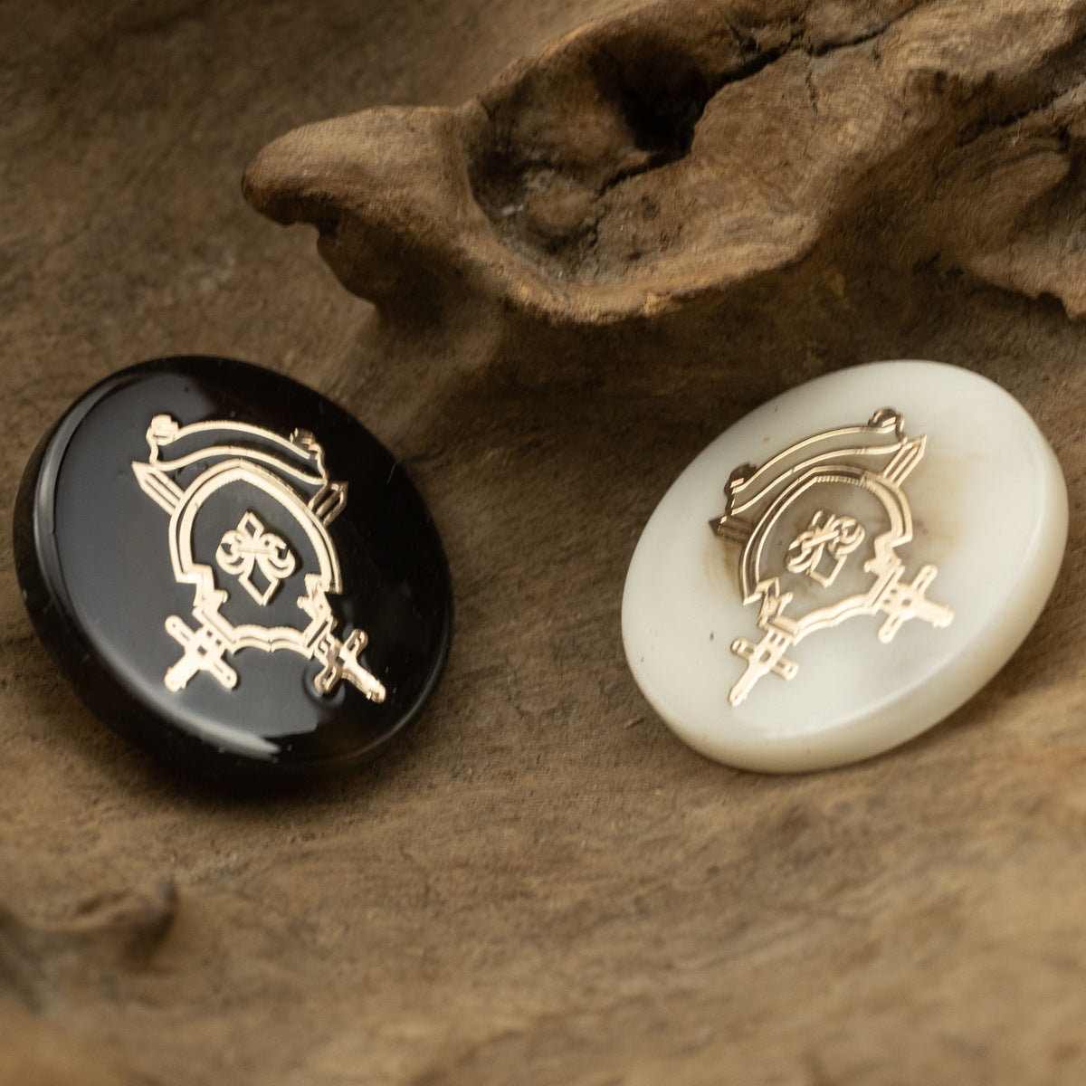 Front of resin anchor crest shank buttons: dark and light with gold-toned emblem