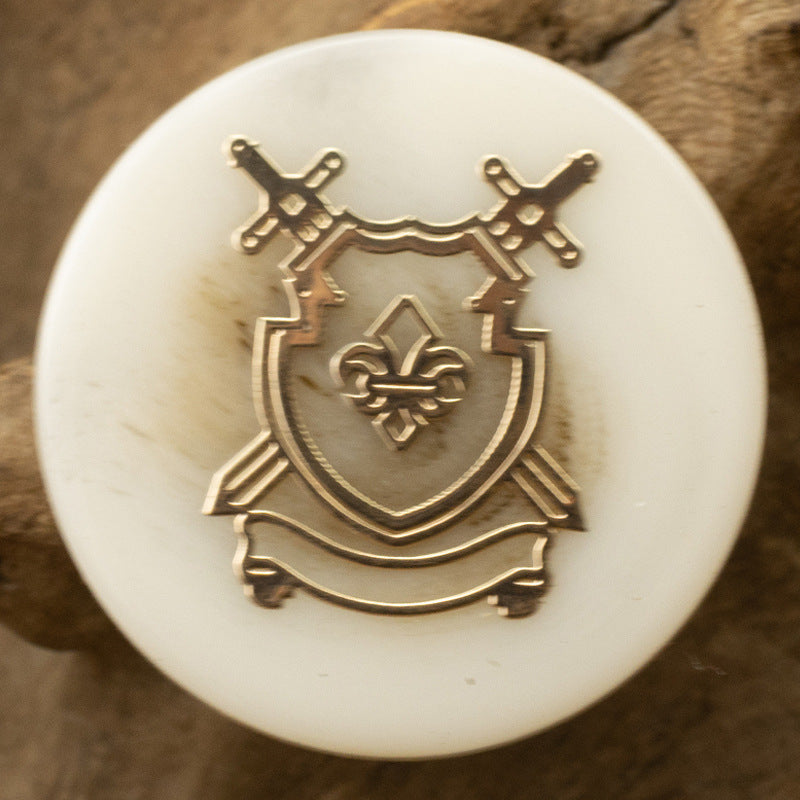 Light resin anchor crest shank button with gold-toned emblem detail