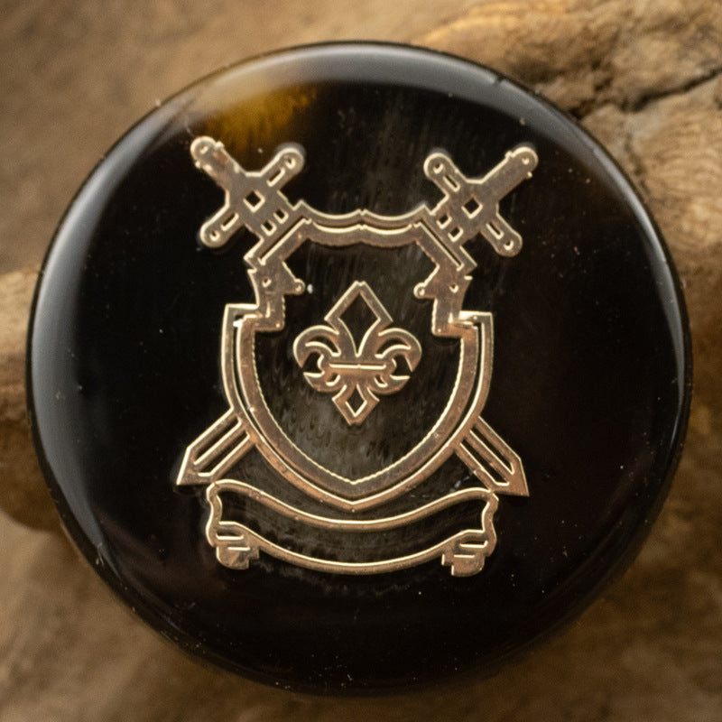 Dark resin anchor crest shank button with gold-toned emblem detail
