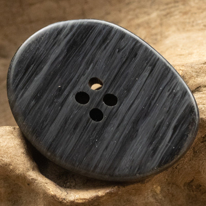 Black large irregular oval resin button, wood-grain style, 4-hole close-up
