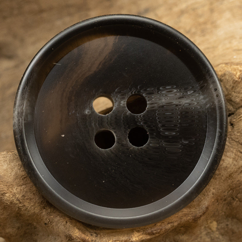 Resin suit button close-up, dark gray-black, 4-hole front