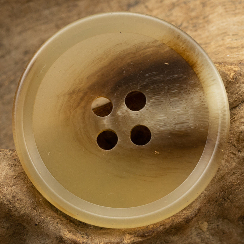 Resin suit button close-up, translucent light amber, 4-hole front