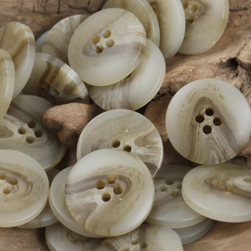 Set of light khaki resin buttons, V-shaped beach pattern, four holes visible