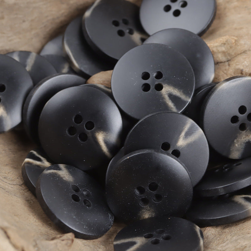 Dark black resin buttons with marbled V-shaped beach pattern and four holes