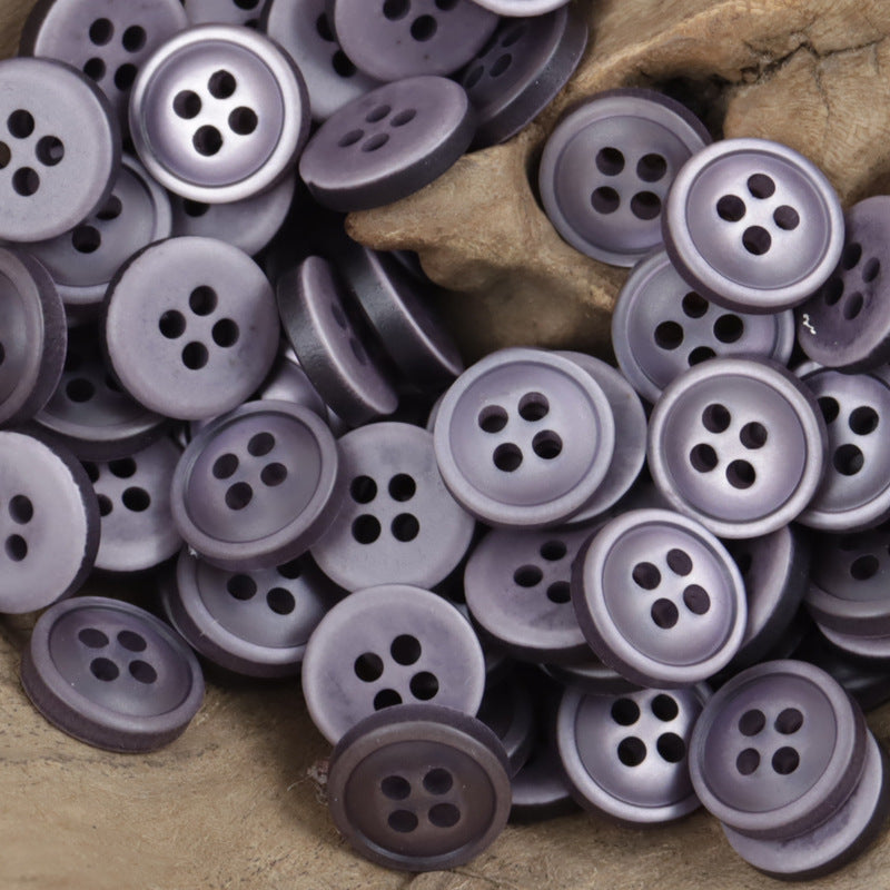 Lilac and slate gray 4-hole resin buttons, 11.5mm, stacked in a mixed pile